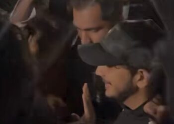Munawar Faruqui is forcefully pushed by an aggressive mob, causing him to stumble and fall, while being silenced with a gag. Meanwhile, the winner of Bigg Boss 17 gracefully makes a public appearance, showcasing their popularity and success.